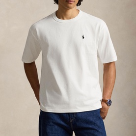 Model wearing Ralph Lauren white crew neck T-shirt with embroidered polo pony logo, styled with dark blue jeans and a watch.