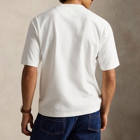 Model wearing Ralph Lauren white T-shirt, back view, short sleeves, relaxed fit, styled with blue denim jeans