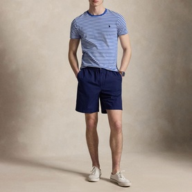 Model wearing Ralph Lauren striped T-shirt in New Iris Blue and White with navy shorts and cream trainers.