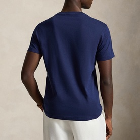 Model wearing Ralph Lauren Newport Navy T-shirt, rear view, styled with white trousers.