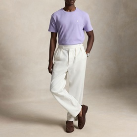 Model wearing Ralph Lauren powder purple crew-neck T-shirt, styled with cream wide-leg trousers and brown loafers.