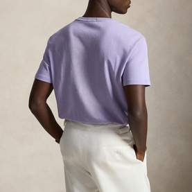 Model wearing Ralph Lauren powder purple T-shirt, back view, styled with cream trousers