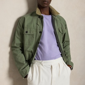 Model wearing Ralph Lauren Powder Purple T-shirt, styled with green military overshirt and white wide-leg trousers.