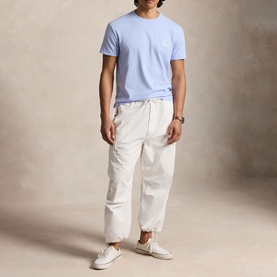 Model wearing Ralph Lauren Pebble Blue crew-neck T-shirt with chest pocket, styled with white cargo trousers and white trainers.