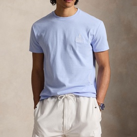 Model wearing Ralph Lauren pebble blue crew neck T-shirt with chest logo patch, styled with white drawstring shorts
