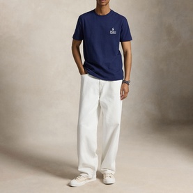 Model wearing Ralph Lauren Newport Navy T-shirt with small chest logo, styled with white wide-leg trousers and white trainers.
