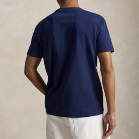 Model wearing Ralph Lauren Newport Navy T-shirt, rear view, styled with white trousers