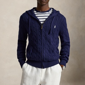 Model wearing Ralph Lauren bright navy cable-knit zip-through hoodie with white pony logo, styled with a blue striped tee and white trousers