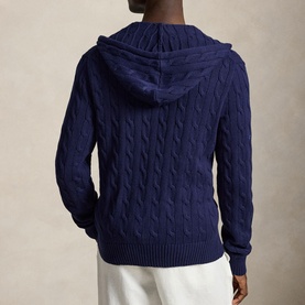 Model wearing Ralph Lauren bright navy cable-knit zip-through hoodie, back view, styled with white trousers