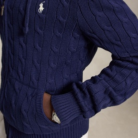Model wearing Ralph Lauren bright navy cable-knit zip-through jumper, white pony logo on chest, close-up detail view.