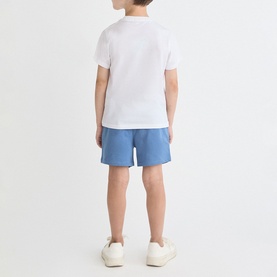 Model wearing Street Monkey White/Blue 2 Piece set, rear view, white tee and blue shorts, styled with white trainers