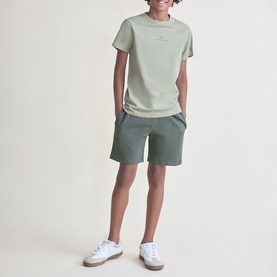 Model wearing Street Monkey Green 2 Piece set, light green tee and darker green shorts, styled with white trainers
