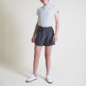 Model wearing Street Monkey Navy Stripe shorts with white tee and white trainers