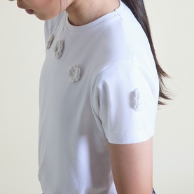 Model wearing Street Monkey white T-shirt with three 3D flower appliqu&eacute;s on chest, short sleeves, crew neck