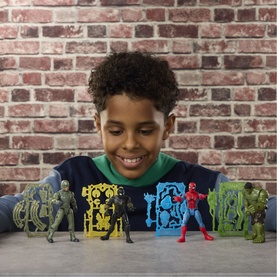 Boy smiling at a set of Superheroes multi-coloured action figures including Spider-Man and Hulk, displayed on a brick wall background
