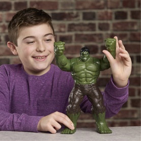 Child holding Superheroes Savage Smash Hulk action figure; large green Hulk toy with raised fists displayed on a table