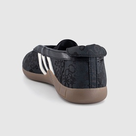 Adidas trainers in black floral print with off-white three stripes, gum rubber sole, rear three-quarter view