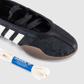 Adidas ballet flat in black floral leather with white three-stripe panel, gum sole, and spare cream laces included.