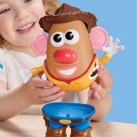 Toy Story Mr. Potato Head Woody figure held by young child, large character toy with blue cowboy outfit and red nose detail