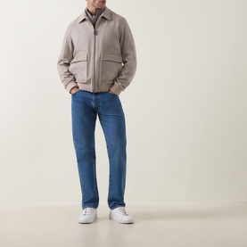 Model wearing Herno cream wool cashmere casual jacket with zip front and patch pockets, styled with blue jeans and white trainers