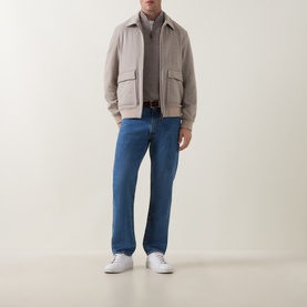 Model wearing Herno cream wool cashmere casual jacket with chest pockets, styled with blue jeans and white trainers.