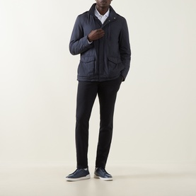 Model wearing Herno navy blue casual jacket with four front pockets, styled with black slim trousers and navy trainers.