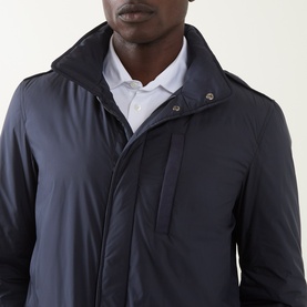 Model wearing Herno navy blue casual jacket with high collar and snap placket, styled with white shirt underneath