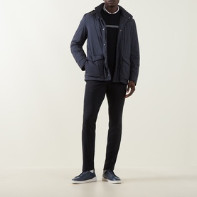 Model wearing Herno navy casual jacket with hood, styled with black slim trousers and navy trainers