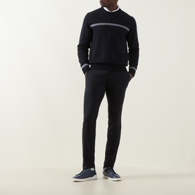 Model wearing Herno Contrast Stripe Sweater in dark blue with grey chest stripe, styled with black trousers and navy loafers.