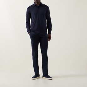 Model wearing Herno Jersey Long-Sleeved Polo Shirt in navy blue, styled with matching navy trousers and cream slip-on shoes.