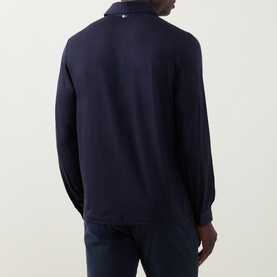 Model wearing Herno Jersey Long-Sleeved Polo Shirt in navy blue, rear view showing polo collar and long sleeves, styled with navy trousers.