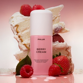 PHLUR Berry Cream Hair and Body Mist 90ml, pink spray bottle styled with fresh strawberries, raspberries and cream cake backdrop