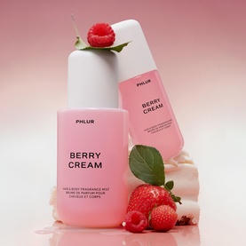 PHLUR Berry Cream Hair and Body Mist 240ml in pink packaging, shown in two sizes styled with fresh strawberries and raspberries on a pink background