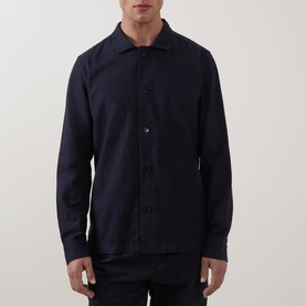 Model wearing Profuomo Garment-Dyed Overshirt in navy, featuring pointed collar, button fastenings, and long sleeves in linen-cotton blend