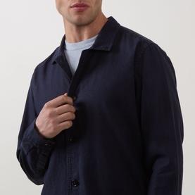 Model wearing Profuomo Garment-Dyed Overshirt in navy, linen-cotton blend with pointed collar and button fastenings, styled over grey crew-neck tee