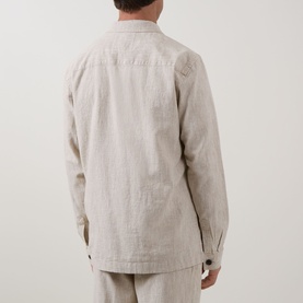 Model wearing Profuomo Notched Collar Overshirt in beige linen-cotton blend, rear view, styled with matching beige trousers.
