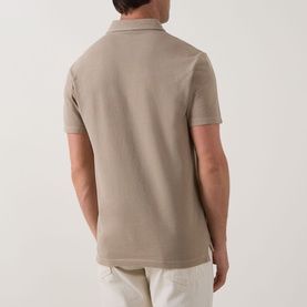 Model wearing Profuomo Garment-Dyed Polo Shirt in beige, rear view, short sleeves, polo collar, paired with light trousers