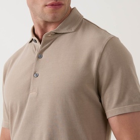 Model wearing Profuomo Garment-Dyed Polo Shirt in beige, close-up of polo collar and three-button placket in 100% cotton piqu&eacute;