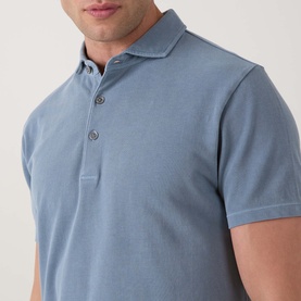 Model wearing Profuomo Garment-Dyed Polo Shirt in grey blue, showing polo collar and three-button placket in close-up crop