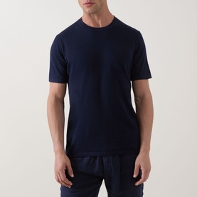 Model wearing Profuomo Solid Knitted T-Shirt in navy, round neck, short sleeves, paired with navy trousers