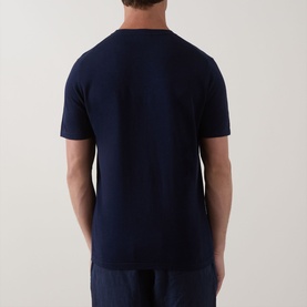 Model wearing Profuomo Solid Knitted T-Shirt in navy, back view, round neck, short sleeves, paired with navy trousers