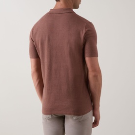 Model wearing Profuomo Solid Knitted Polo Shirt in clay, rear view showing polo collar, short sleeves and straight hemline, styled with light grey