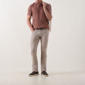 Model wearing Profuomo Solid Knitted Polo Shirt in clay with light grey trousers, dark brown belt and navy shoes.