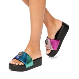 Model wearing Kurt Geiger London Meena Eagle Head Platform Slides in multi rainbow stripe with silver eagle head detail on black platform sole