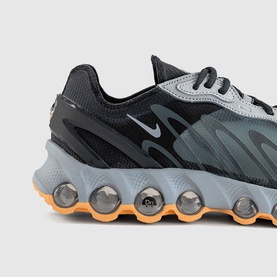 Nike men's trainer in cool grey and black with orange-tinted bubble sole unit, close-up detail of heel and midsole