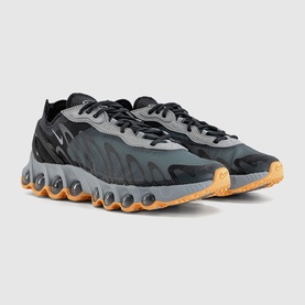 Nike men's trainers in cool grey and black with orange-yellow zigzag sole, shown as a pair at an angle
