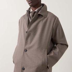 Model wearing Hugo Boss open brown houndstooth wool coat with button front, styled over a grey layered vest and tie.