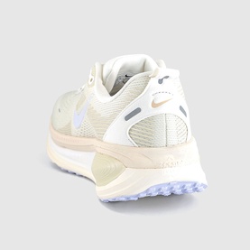 Nike trainer in Summit White, White and Chalk colourway, shown from rear angle highlighting padded collar, mesh upper and light rubber sole.
