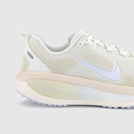 Nike trainer in Summit White with iridescent midsole, white Swoosh logo, mesh upper, and pale pink heel detail.