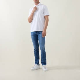 Model wearing Boss Black Casual C-Parris Logo Polo Shirt in white with blue slim-fit jeans and white trainers.